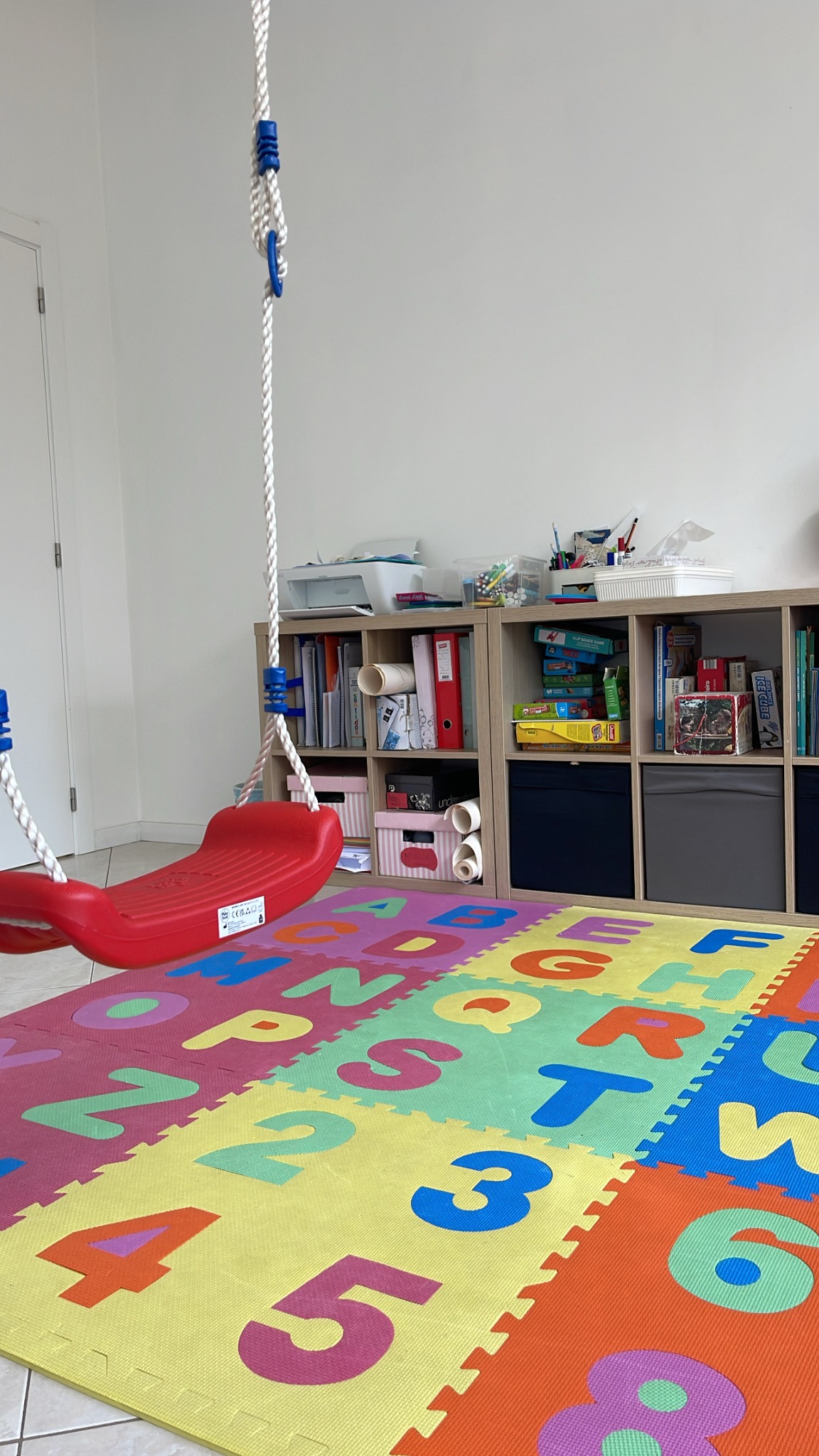 Sala terapêutica do Espaço Evoluir com baloiço e tapete infantil